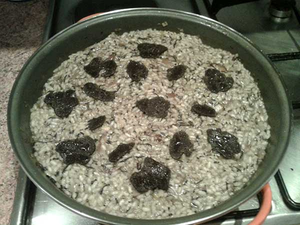 Risotto en sartén con láminas de trufa negra.
