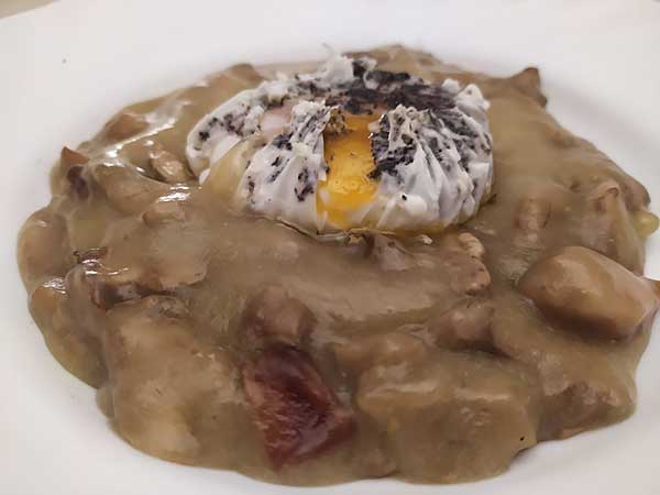 Huevo poché con trufa sobre crema de champiñones y jamón.